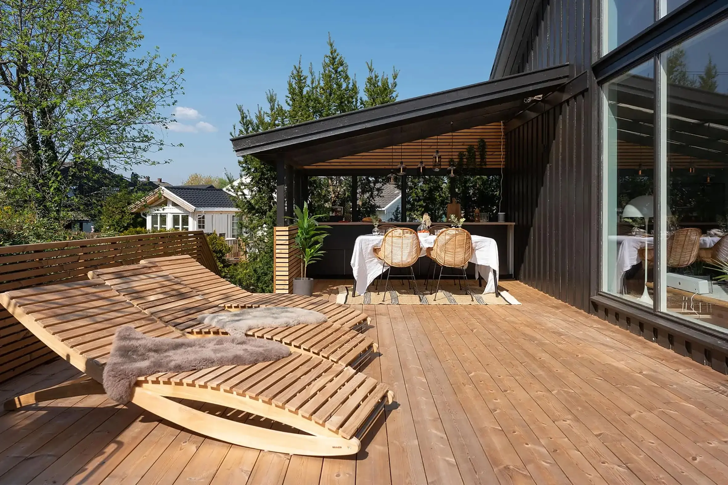 Lounge-Terrasse mit Thermokiefer-Dielen und Liegestühlen. Terrasse lounge en pin thermo avec chaises longues.
